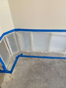 Water damage mitigation with aluminum barrier in progress at a residential property. Aluminum moisture barrier installed on the base of a wall to protect against water damage, part of professional water damage restoration process by A+ Integrity Restoration.