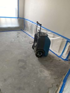 Water damage restoration process with professional drying equipment for residential and commercial properties. Dehumidifier for water damage restoration in residential property, industrial equipment used for drying and controlling moisture levels.