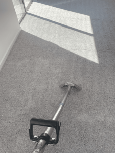 Freshly cleaned carpet with a professional-grade commercial spotter in action, highlighting expert carpet cleaning services by A+ Integrity Restoration for home and business damage restoration.