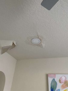 Ceiling water damage repair and restoration specialists focusing on water leak mitigation and damage restoration by A+ Integrity Restoration. Water damage ceiling with a hole due to leak repair, residential home restoration, mold removal, water damage mitigation, ceiling repair services, water damage restoration expert.