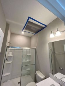 A bathroom ceiling with a damaged and moldy area being repaired after water damage, showcasing professional restoration services by A+ Integrity Restoration. Ceiling water damage repair in bathroom with drywall replacement and mold remediation by A+ Integrity Restoration. Expert water damage restoration services for residential and commercial properties.