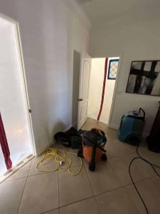 Photo of water damage restoration process showing tools and equipment used by A+ Integrity Restoration for flood and water damage repair. Wet drywall repair and water damage restoration in a residential room by A+ Integrity Restoration. Skilled water damage specialists handle storm, flood, and leak cleanup.